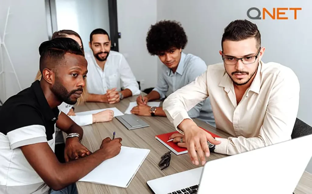 A young QNET distributor working along with a teammate on computer