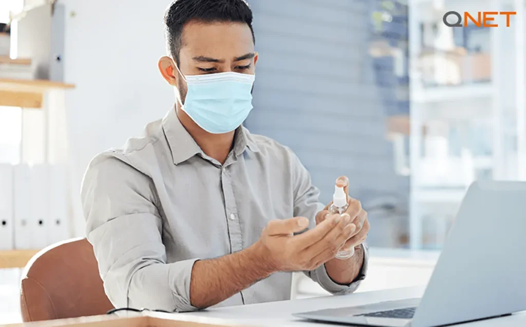 An employee using sanitiser