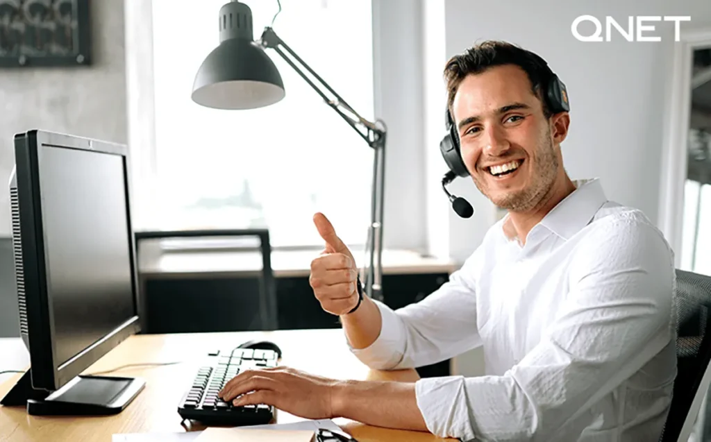 A man giving a thumbs-up in office