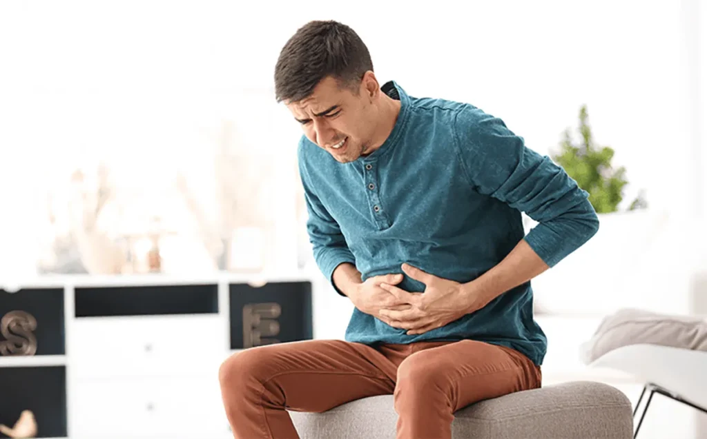 An individual experiencing stomach problems due to a poor diet